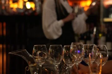 A bartender preparing drinks behind the Fiaba Brasserie bar