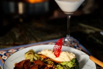 A plated main course beside the fireplace at Fiaba Brasserie